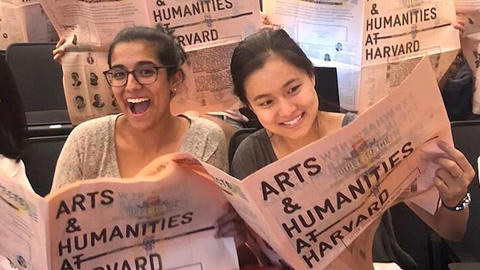 Students looking through the Arts and Humanities newsletter